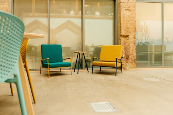 Two brightly coloured chairs and a table in the reception area at EWIC.