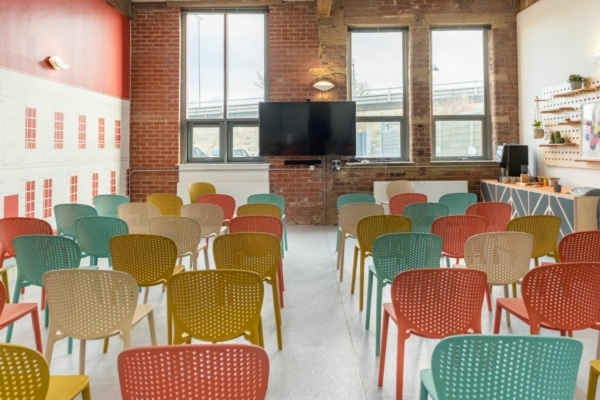 Rows of chairs set up for a meeting or talk at EWIC. There is a TV screen at the back of the room.