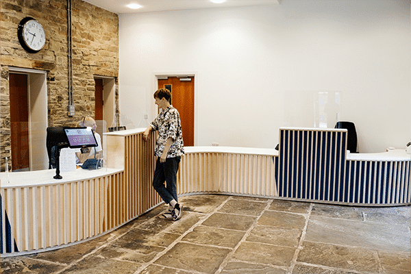 Person stood talking to the receptionist at EWIC.